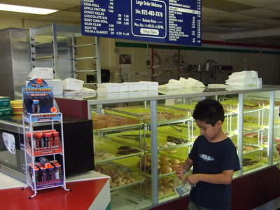 Image: How Many Donuts Can I Buy — This young man is making sure he has enough money for his donuts.