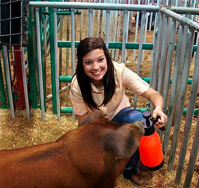Image: Morgan and “80” — Morgan Cockerham spends some quality time with her Duroc swine, Kinsler, all 242 pounds of him.