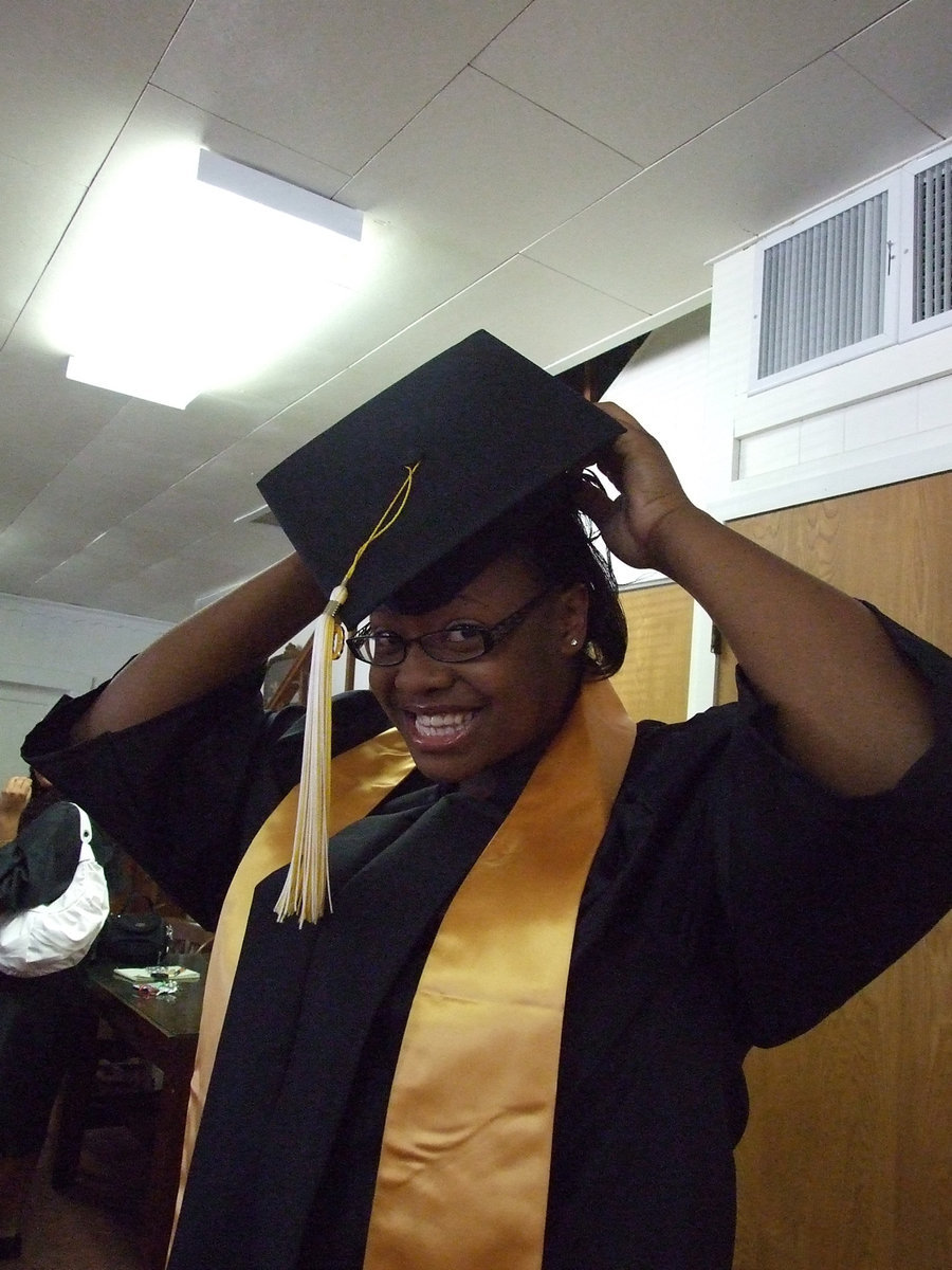 Image: Jasmine tries on her cap — Which way does that tassel hang anyway?