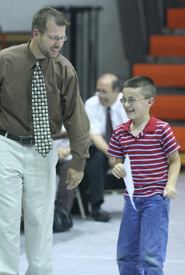 Image: Excited — Lane cannot contain his excitement over getting his Physical Education Award from Mr. Morgan.