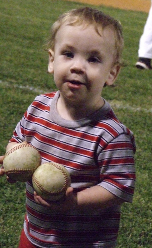 Image: I wanna play too — Kix Bales, Coach Craig Bales’ youngest son, helps the team by cleaning up the field after the game against Whitney on Friday night.  The Gladiators put a check in the “Win” column.