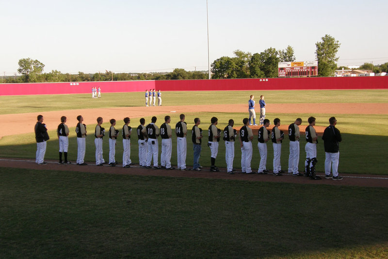 Image: Showing respect — The Italy Gladiators stand in formation during the National Anthem before taking on Windthorst for the Area title. Windthorst who was ranked 2nd in Class A, ultimately won the contest 9-3.