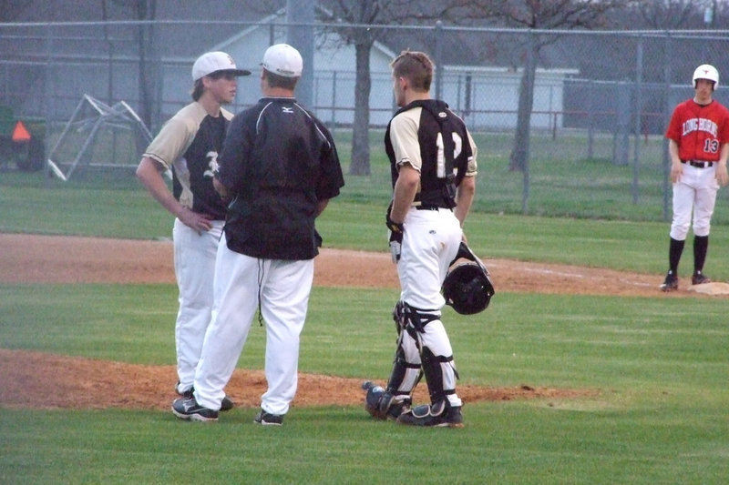 Image: A short visit to the mound — Coach Ward, Ryan and Buck talk about the rest of the inning.