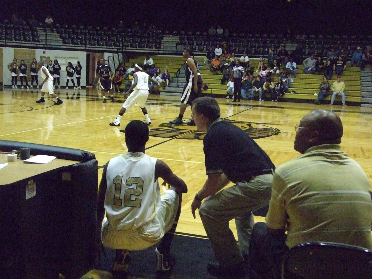 Image: Coach and player — Coach Holley preps #12 Aaron Thomas for action. Aaron is following in his father’s footsteps by playing for the Gladiators.