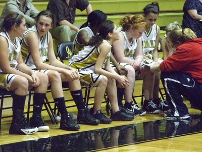 Image: Coach McDonald strategizes — A passionate, basketball loving 8th Grade Girls squad, is all business on the bench.