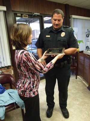Image: Here Is Your Award — Shanna Dunn (Ellis County Volunteer Co-ordinator for Meals on Wheels) presents this award to Chief Phoenix.