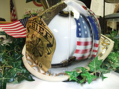 Image: Special helmet for a special Chief — One of Chief Chambers’ favorite gifts was on display during the party. The one of a kind fire helmet was used as the center piece for the decorations.