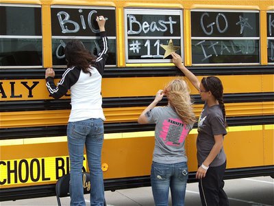 Image: Decorating — Delma Garcia, Sierra Harris and Anna Viers help decorate the bus windows.
