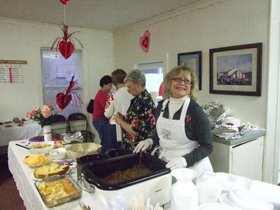 Image: Jan cheeses — Jan Parker takes a minute to grin during the chili fundraiser.