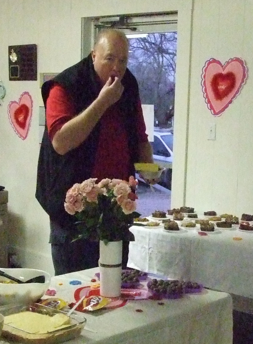 Image: Bob grabs a bonbon — Bob Reeves grabs dessert while waiting for his bowl of chili.