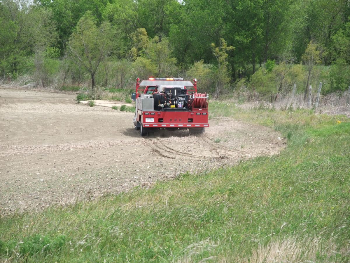 Image: I.F.D. jabs at the fire — I.F.D. jabs at the grass fire trying to find a way to get in closer.