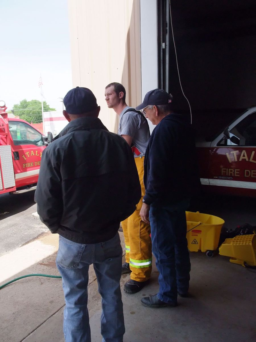 Image: Back at the station — Firefighters Sal Perales, Eric Bradley and Chief Donald Chambers clean the equipment after the grass fire.