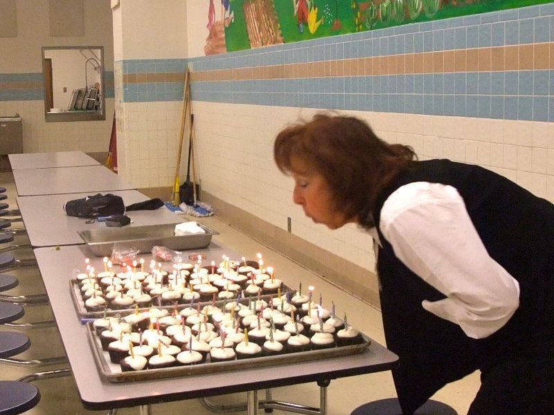 Image: Blowing out the candles — Cupcakes for everyone! Charlotte Morgan (1st grade teacher) is blowing out the candles.