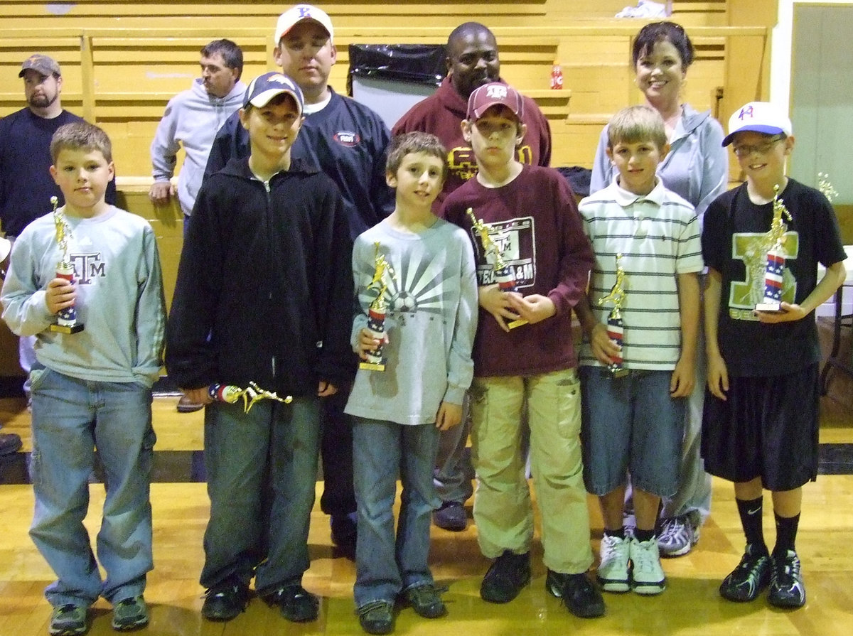 Image: Striking a pose — Head Coach Andrea Windham and Asst. Coach Scott Conner pose with their squad as they receive their trophies for a job well done in the IYAA this season.