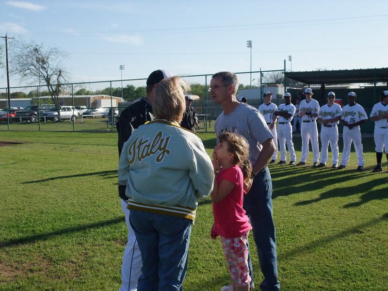 Image: The Varners — Kym and Stevan Varner, of Varner Fina, greet Coach Matt Coker at the pitcher’s mound before their daughter Jill Varner, who was brought up from the minor leagues, throws out the opening pitch. STRIKE!