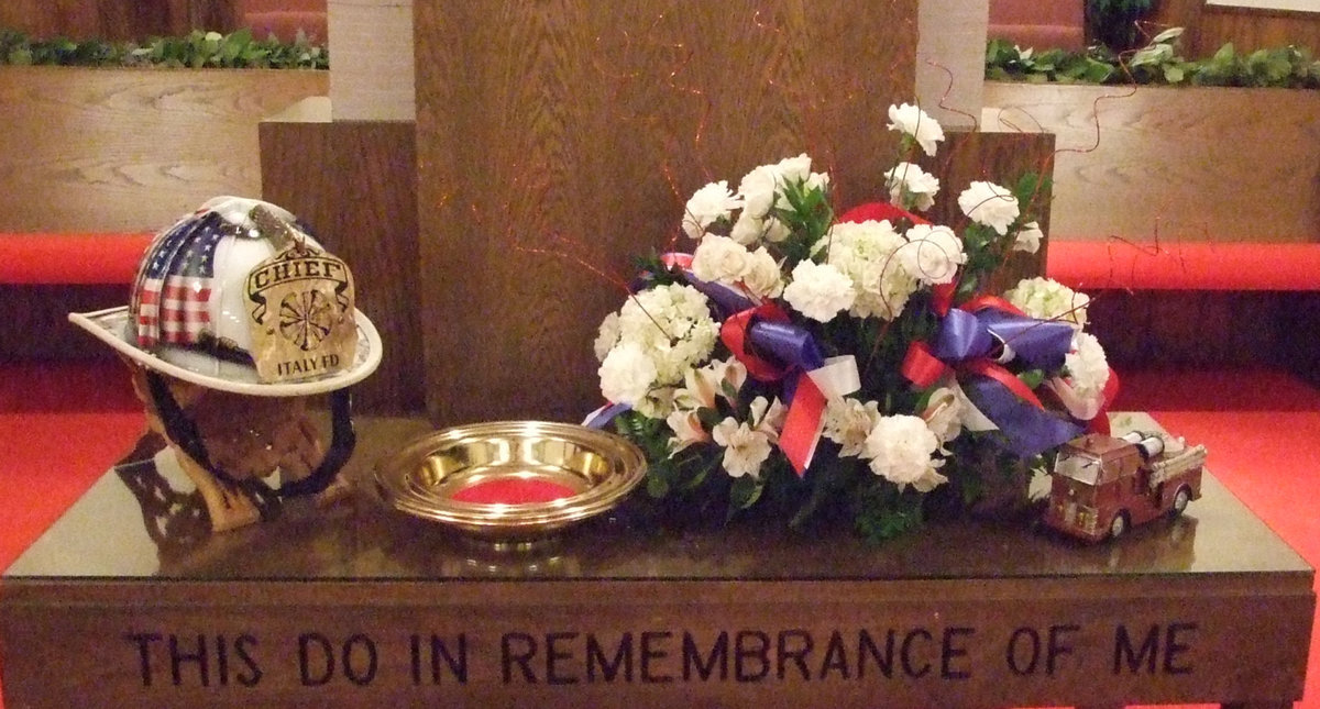 Image: The altar at First Baptist — The flowers are in honor of Todd Bell, fireman, co-worker and friend.