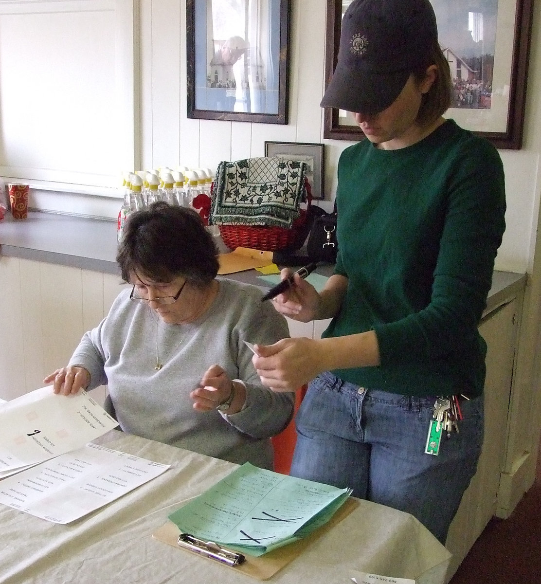 Image: Lots of paperwork — Karen Mathiowetz and Rev. Krista Ingram check the lists more than twice.