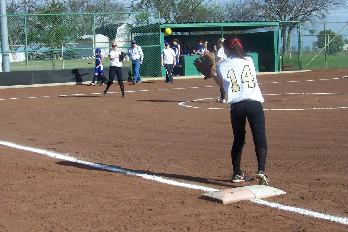 Image: Warm-ups — Megan “Rich” Richards warms up her arm during infield warm-ups between innings as she fires a shot to Drew Windham on 1st base..