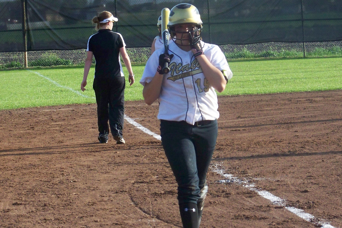 Image: Cori is up — Cori Jeffords snugs up her helmet after a brief conference with Coach Reeves.