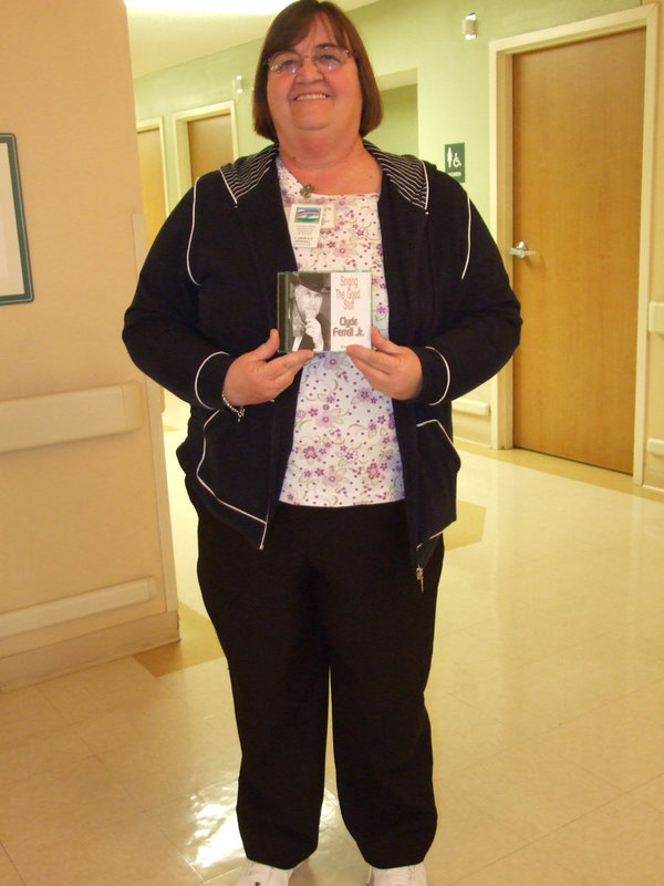 Image: Carolyn Powell — Carolyn Powell (activities director) showing us Clydes cd, “Singing the Good Stuff”.