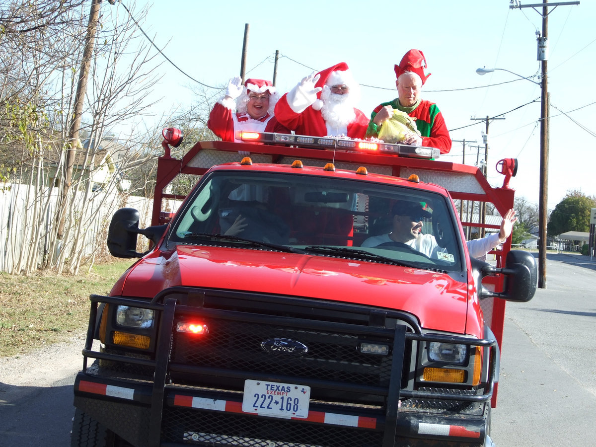 Image: Santa has come to town — Mr. and Mrs. Claus were guests in the Italy Festival on Saturday.  Santa had to rush back to the North Pole to be ready for the 25th.  Elf Crownover was happy to give out candy.