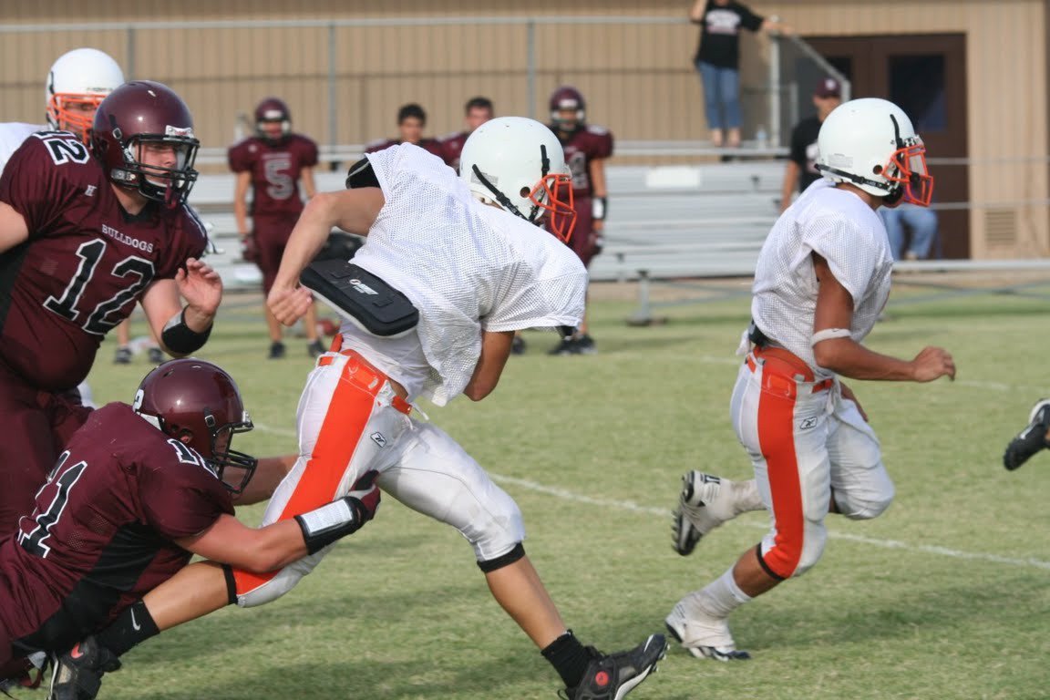 Image: Scrambling — Avalon’s Quarterback tries to break free from a couple of persuing Bulldogs.