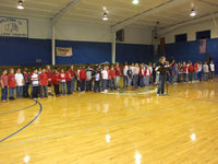 Image: Laura Harvey Welcoming Guests — Milford 2nd through 5th grades ready to sing.