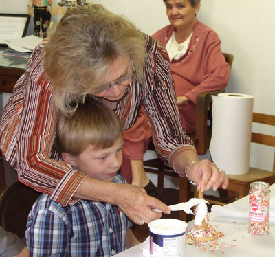 Image: Frosting with Ethan — After you attach the cone to the cookies, frost with cake frosting and use sprinkles for extra fun. Jan Parker has fun with her grandson, Ethan.