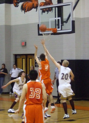 Image: Cockerham Goes Up — #5 Cockerham takes the shot even with 2 defenders on him at the Avalon vs. Forestburg game.