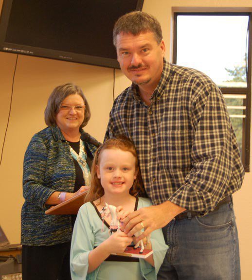 Image: Andy and Sadie Hinz — Andy Hinz representing ECEA sponsor Flying Dollar Ranch presents his daughter Sadie Hinz with a Painted Pony collectible for winning the Walk and Whoa Championship, while ECEA treasurer Sandy Neal looks on.