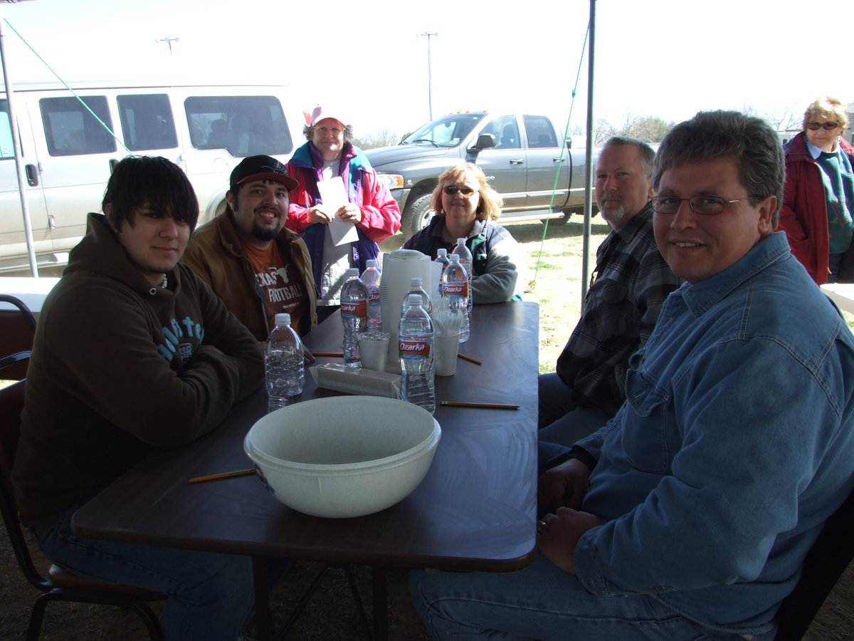 Image: Judges  — These judges were judging the final round of chicken. Glenda Bowling (at the very back of the table) said,“I am the head judge for the Lone Star BBQ Society and am running the cook off. I have been doing this for four years. We do these cook-offs to help raise money for charities.”