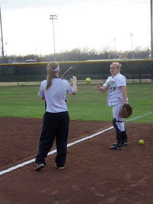 Image: Catching-In — Julia McDaniel catches in for Coach Reeves during pre-game infield drills.