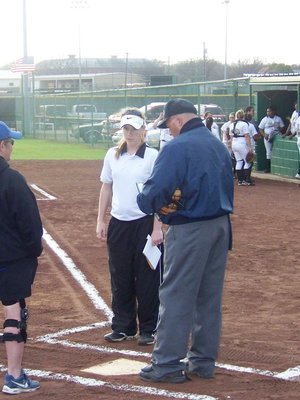 Image: Meeting at the plate — The coaches have their pre-game meeting at the plate with the umpires.