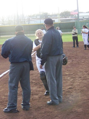 Image: Knuckle Knock — Julia McDaniel knocks knuckles with the umpires during her introduction.
