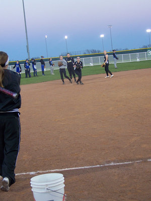 Image: Warm-ups — Head Coach Jennifer Reeves hits ground balls to the infielders before the game.