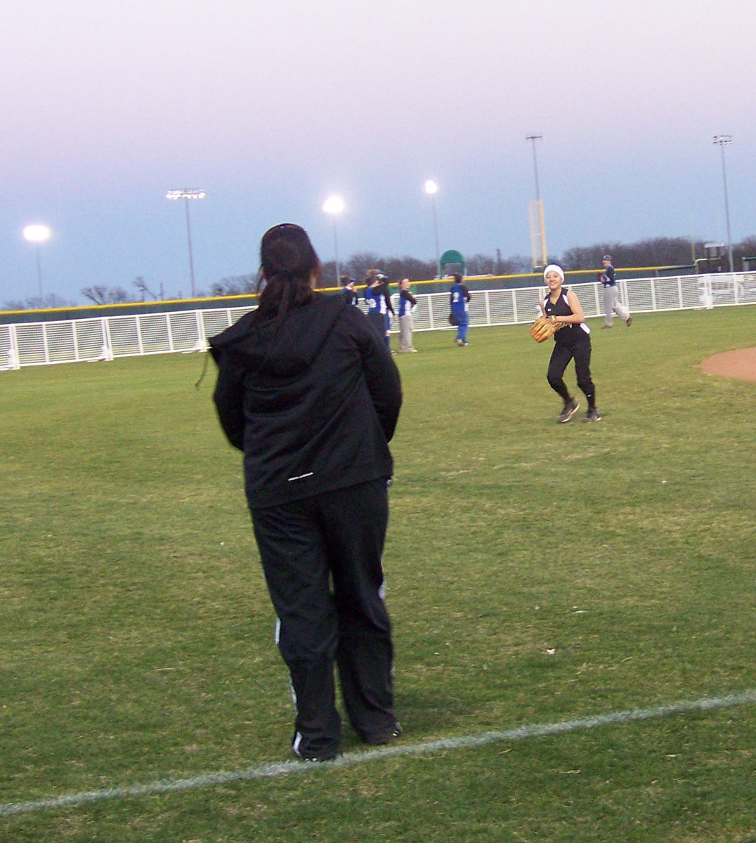 Image: Outfield reps — The outfielders take reps before the game supervised by Assistant Coach Tina Richards.