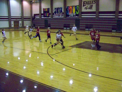 Image: Wallis fast breaks — Tara drives the ball as McKenzie, Jaclynn, Kabreona and Madison run the floor.