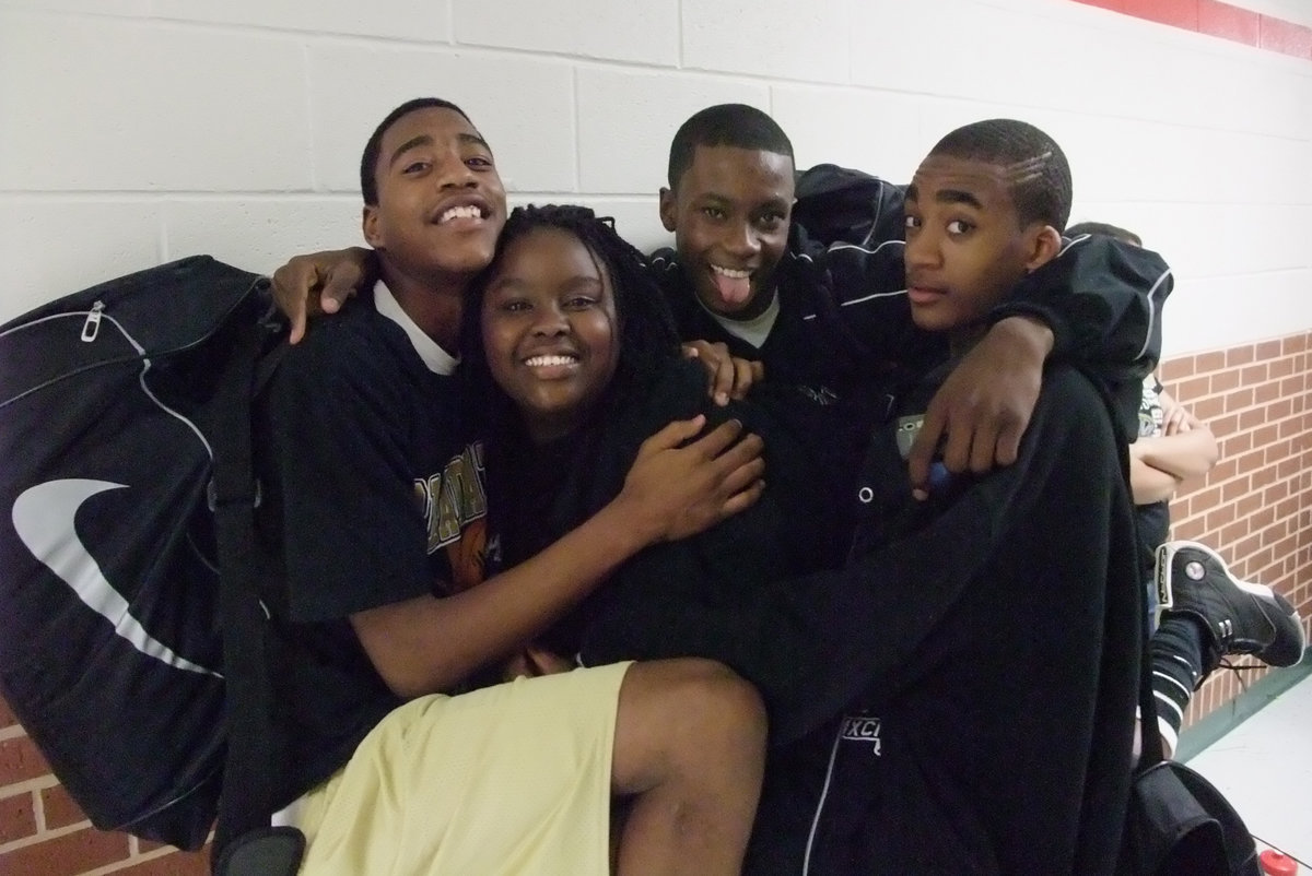 Image: Gladiators embrace after Bi-District win — After winning the Bi-District game against the Chilton Pirates 87-73, Darrin Moore, Shanta Thomas (Game Filmer), Aaron Thomas and Heath Clemons embrace in a celebratory hug.