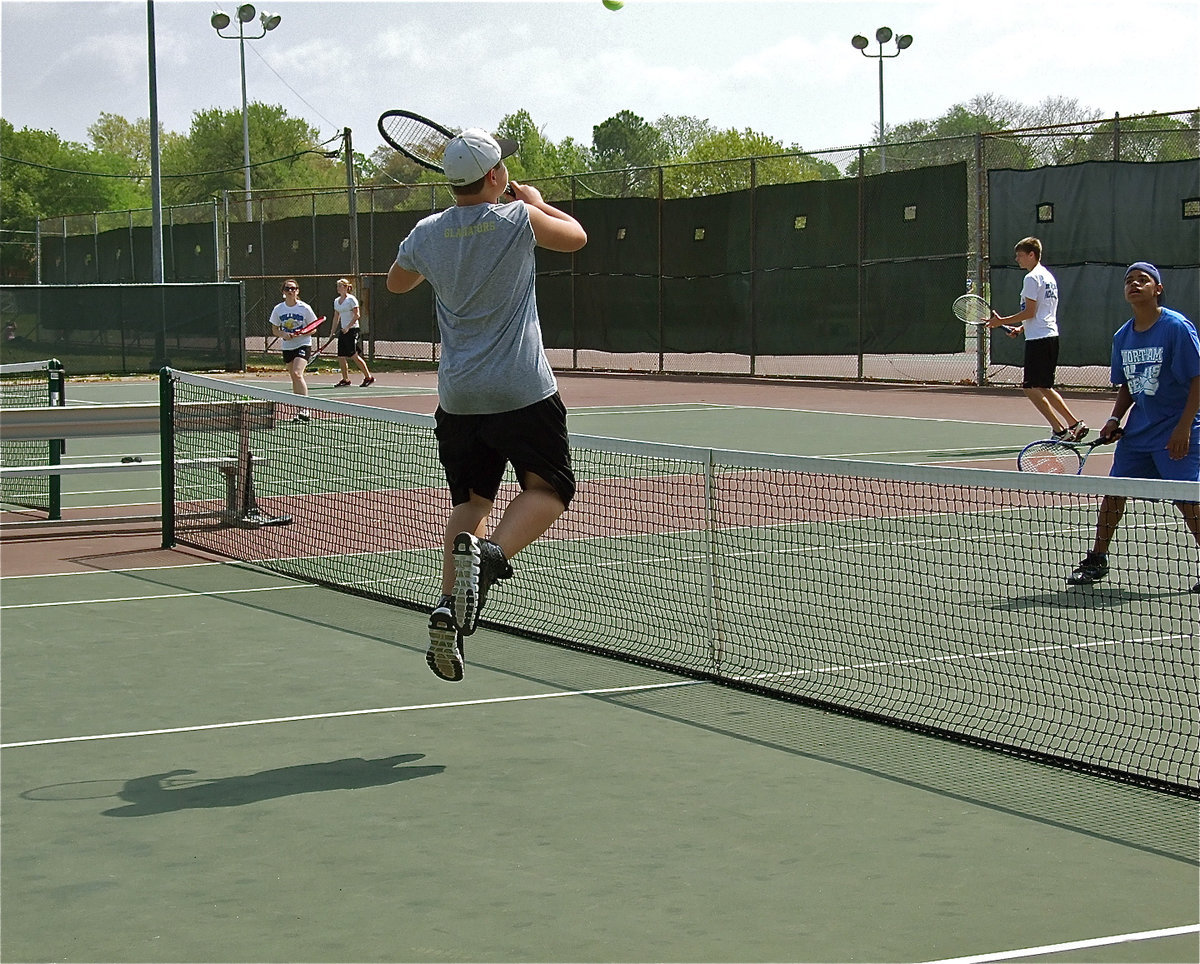 Image: Above the net — Zain Byers attempts a high-flying spike against Wortham during JV doubles competition.