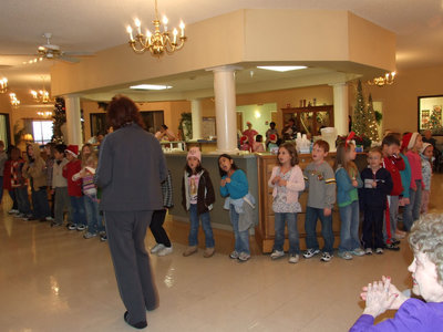 Image: First Graders — First graders singing Christmas songs under the direction of their teacher, Mrs. Morgan.