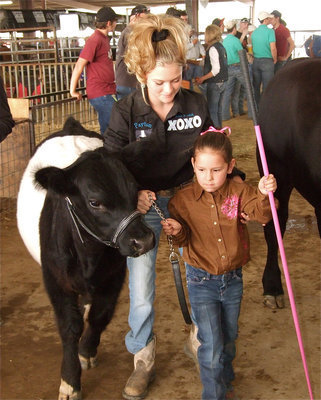 Image: No problem — Italy’s Ella Hudson has everything under control with a little help from Payton Gerloff, who is representing Double M Ranch out of Red Oak, as Hudson enters the show ring for PeeWee Showmanship.