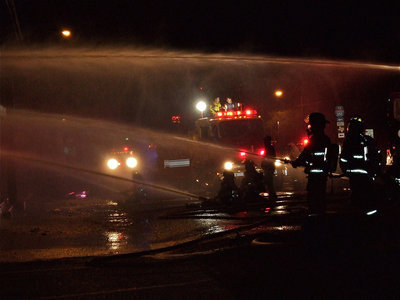 Image: Water works — Fire crews keep constant pressure on the flames from Main Street in Milford.