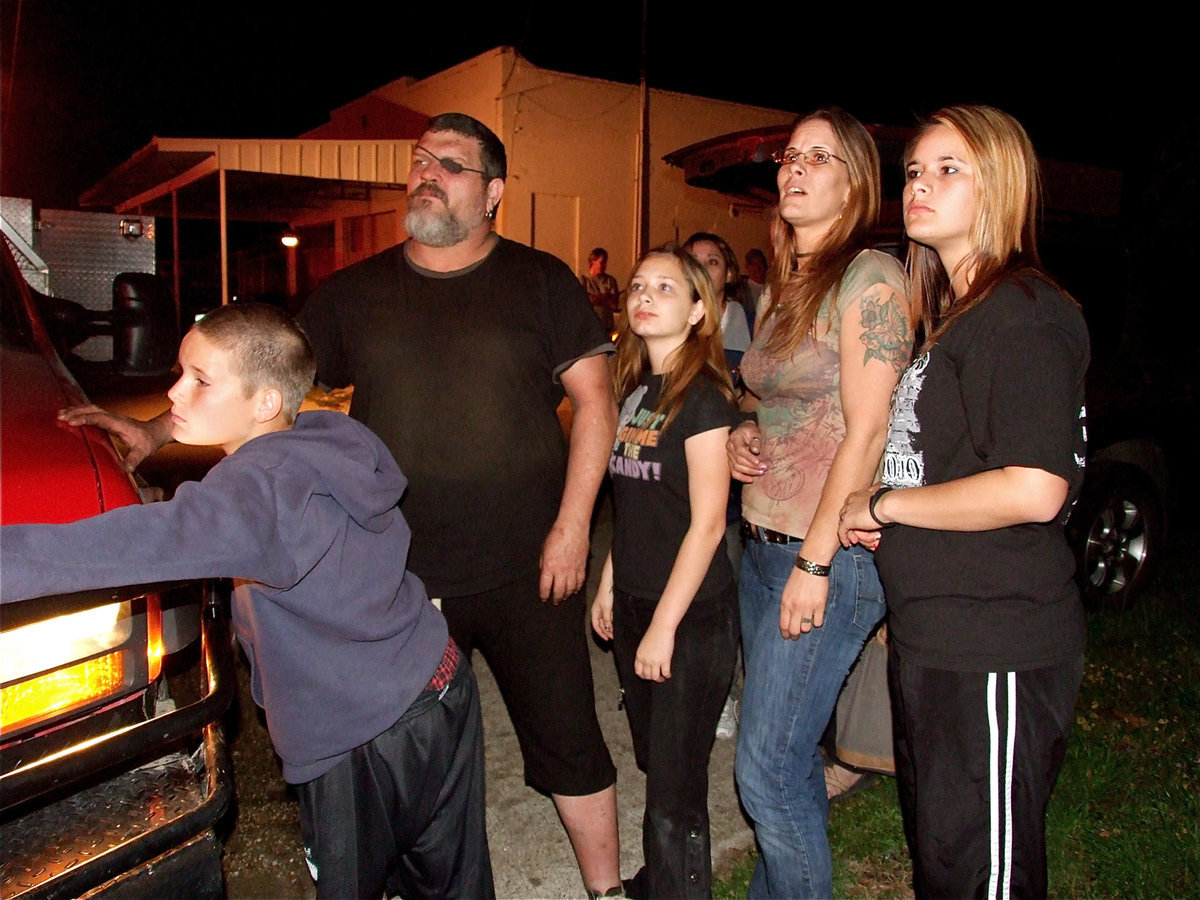 Image: Stunned residents — Along with friends and neighbors, Isaac Salcido, Paige Kelley, Candi Gray-Salcido and Jasmine Salcido witness Milford Cash Grocery being lost to a relentless fire.