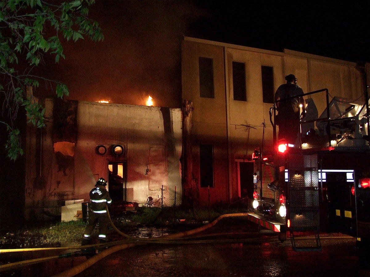 Image: Surrounding the fire — Firefighters begin to spray water in from the backside of the grocery store.