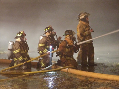 Image: Manning the hose — Fire crews work diligently to control the fire.