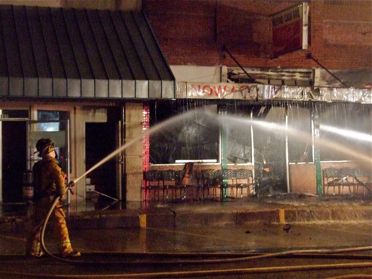 Image: Total damage — A frontal view of Milford Cash Grocery shows the melting awning, shattered windows and burnt timbers.