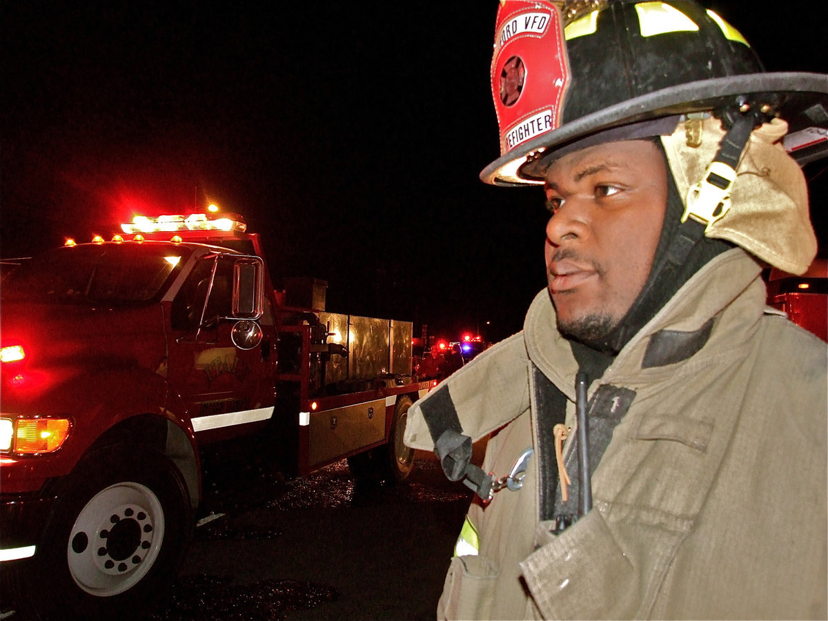 Image: Difficult to watch — Milford firefighter, Alan Singleton, looks on as Milford’s only grocery/convenient store is completely lost in the fire.