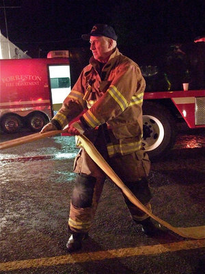 Image: Clearing the scene — With the fire under control, crews begin to roll up some of the hoses.