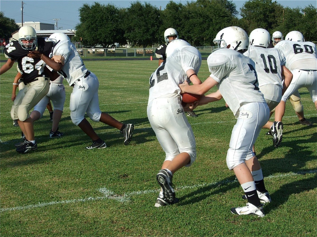 Image: John hands to Cody — John Escamilla(7) handsoff to Cody Boyd(22) who follows Coby Bland(10) thru the hole created by the offensive line.
