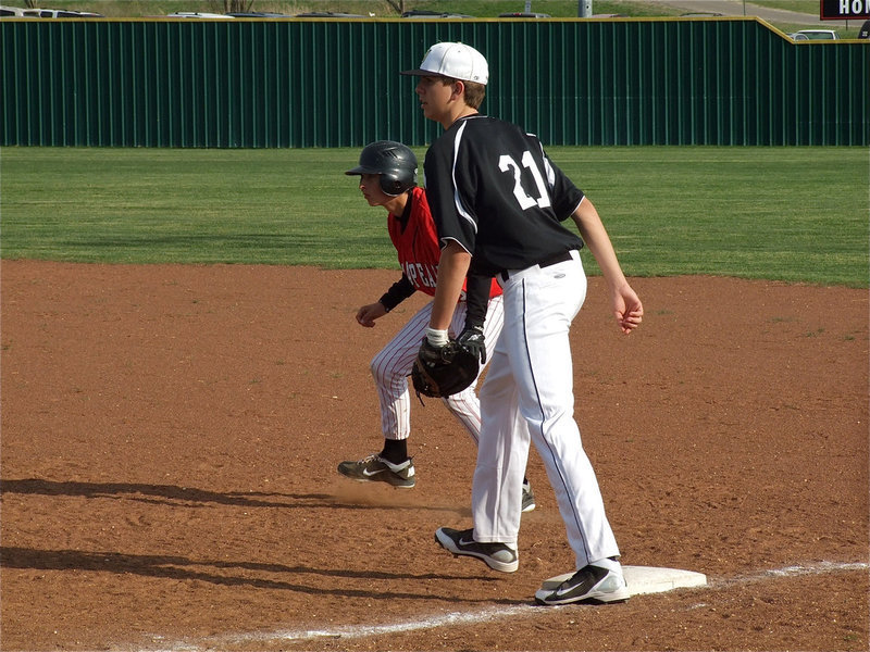 Image: Cole’s on first — Italy JV Gladiator, Cole Hopkins(21) tries to hold a Maypearl runner on first base.